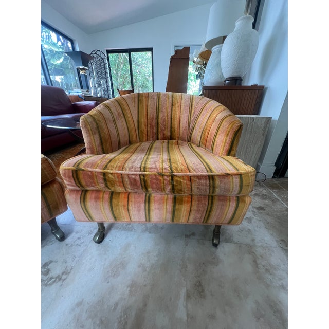 Pair of mid-century modern barrel back club chairs in the style of Harvey Probber, upholstered in colorful striped velvet...