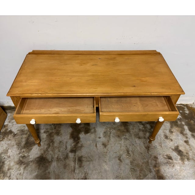 This charming 19th century English pine writing table is a true testament to timeless craftsmanship. Hand-selected and...