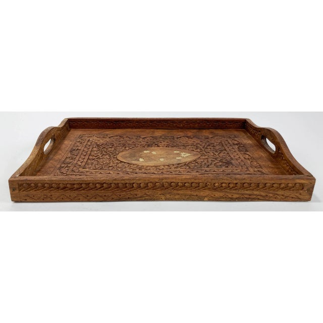 Beautiful hand-carved Shesham wood tray from India. Features floral pattern throughout with brass inlaid center. Carved...
