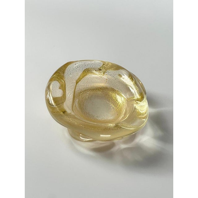 A decorative freeform shaped Murano glass bowl by Archimede Seguso, hand-crafted in Italy during the 1980s. The small bowl...