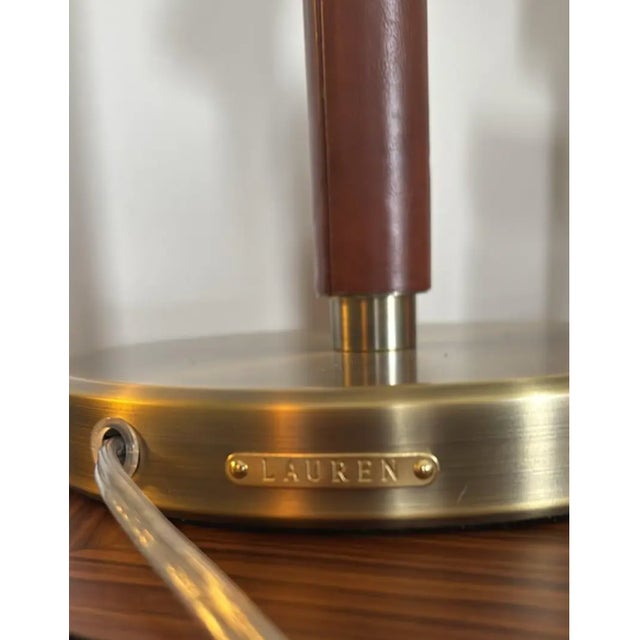Striking pair of authentic Ralph Lauren Home campaign-style table lamps featuring brushed brass metal shades, brown...