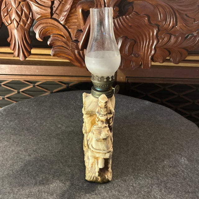 This vintage oil lamp is made of porcelain and depicts a horse-drawn carriage driven by a coachman, with a lady exiting...