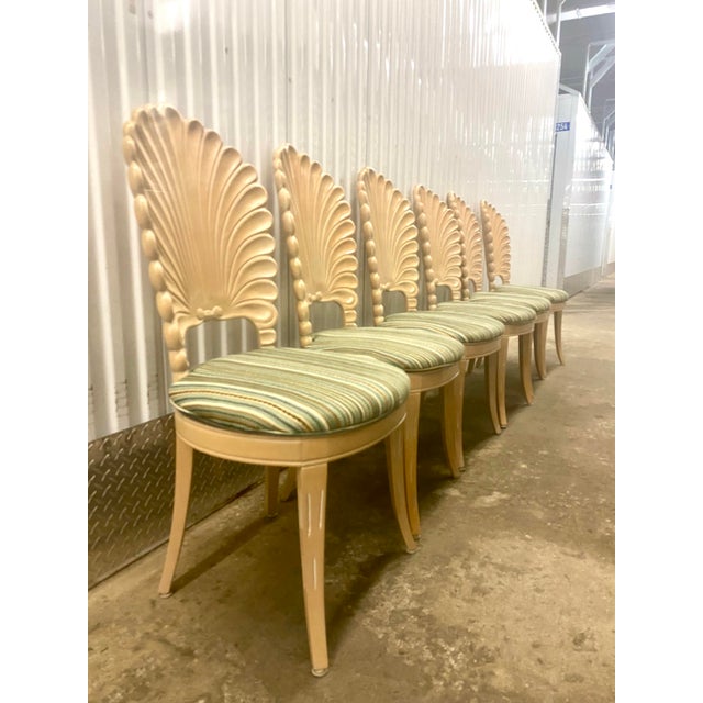Venetian Grotto-style scalloped shell-back dining chairs, featuring carved wooden shell or fan motifs on the backrests and...