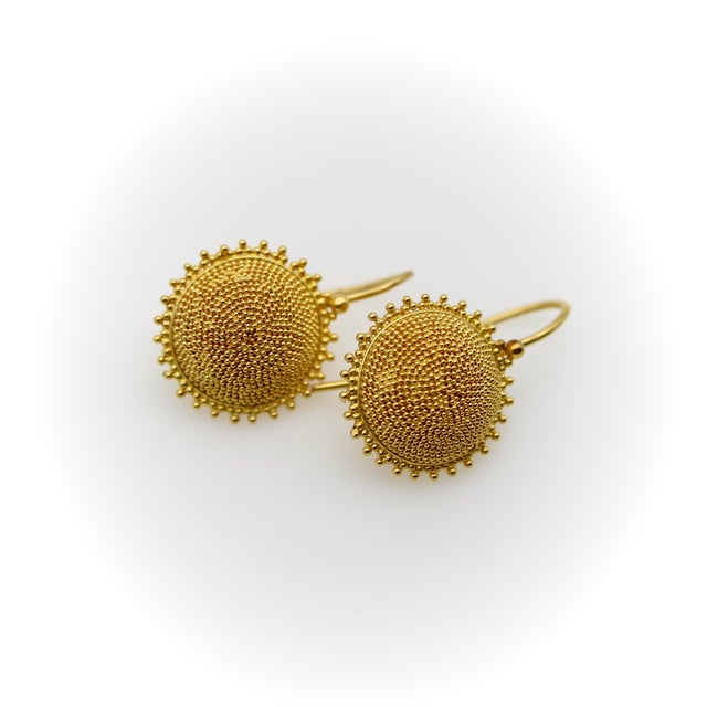 When looking at these sunflower shaped earrings, what strikes us first is the texture that’s been created by the gold...