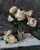 "Roses on Grey" is an oil on panel painting by Jon Doran, completed in 2026. A bunch of white roses rises from a clear...