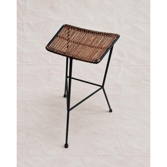 A mid-century bar or counter stool attributed to Dennis Lennon, dating to circa 1950s. The hand-woven rattan cane seat is...