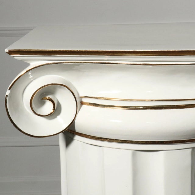 A gorgeous white with gold detailing ceramic ionic column and lotus urn. Marked Italy. Circa 1960’s. Show stopping piece....