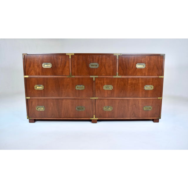 Iconic mid-century modern Campaign style seven-drawer dresser, chest of drawers; 1950s production by Baker Furniture....
