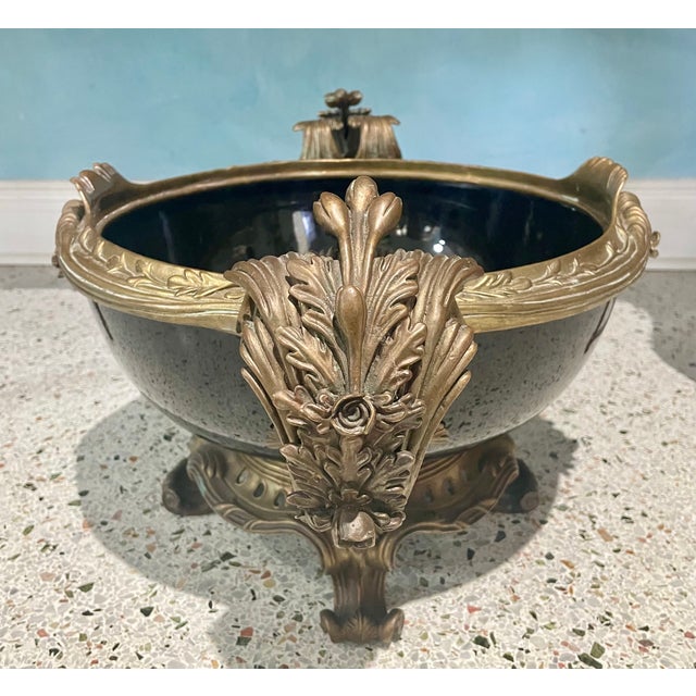 A striking vintage Rococo-style jardinière featuring an elegant dark patinated metal body accented with beautifully...