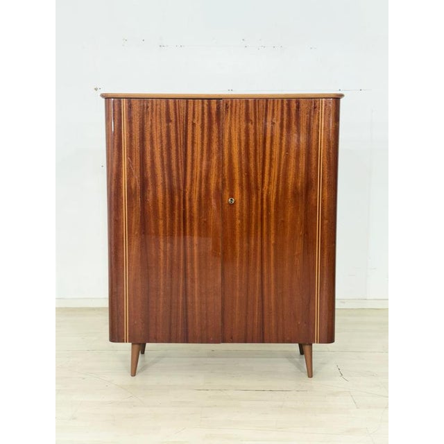 Beautiful, original vintage wardrobe in an elegant mid-century design. The piece impresses with its exquisite mahogany...