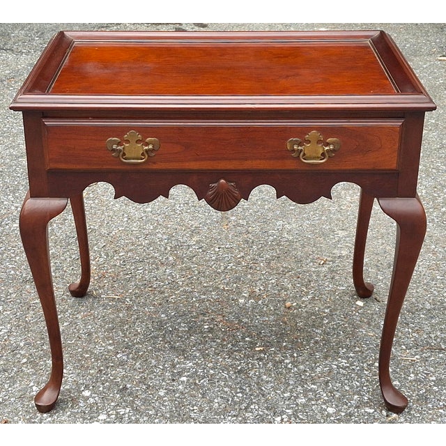 A Queen Anne Style Cherry Tea Table with Pull-out Trays from the mid 20th Century Measures 29" in width , 17" on depth,...