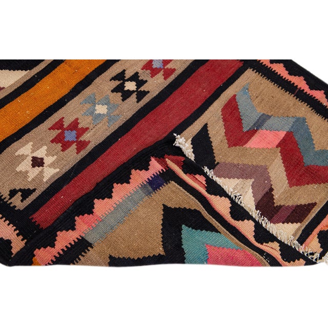Beautiful vintage Turkish Kilim hand-knotted wool rug with a tan field. This piece has multicolor accents in an all-over...