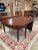 This is a graceful pair of antique mahogany drop-leaf dining tables that can be used individually or joined to form a...