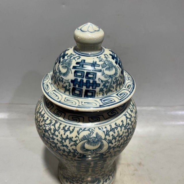 Traditional Chinese blue and white lidded ginger jar decorated with hand-painted interlocking vine and peony floral...