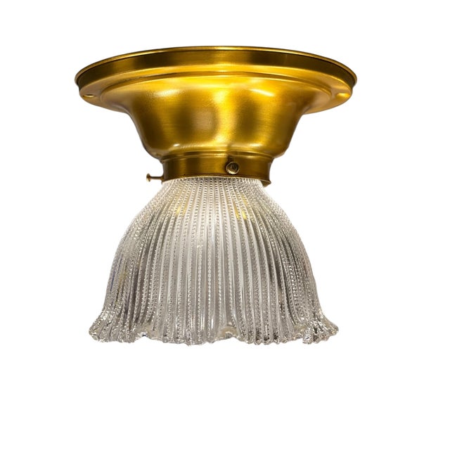 Classic clear glass Holophane shade on a vintage brushed brass fixture. We added an internal cover for a modern junction...
