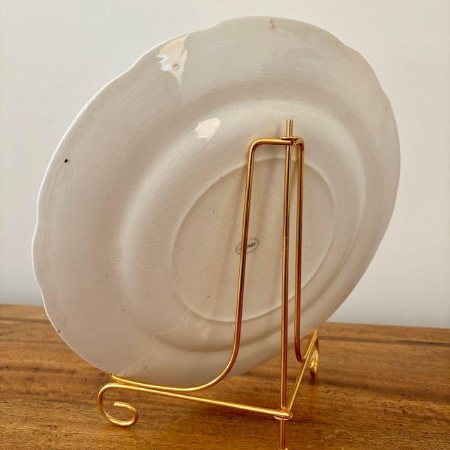 Beautiful green and gold rimmed hunting dog plate displayed on a gold stand. Features a German shorthaired pointer in a...