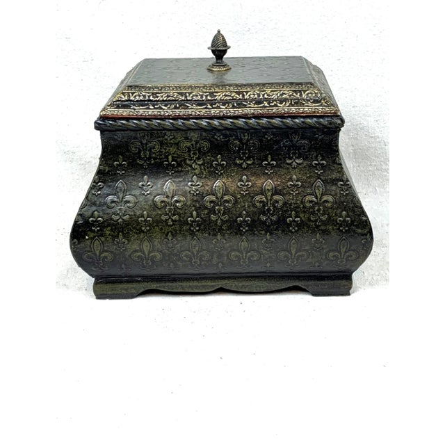 Wonderful vintage wooden box. Features a fleur de lis design with a metal finial on the lid. The color is a dark...