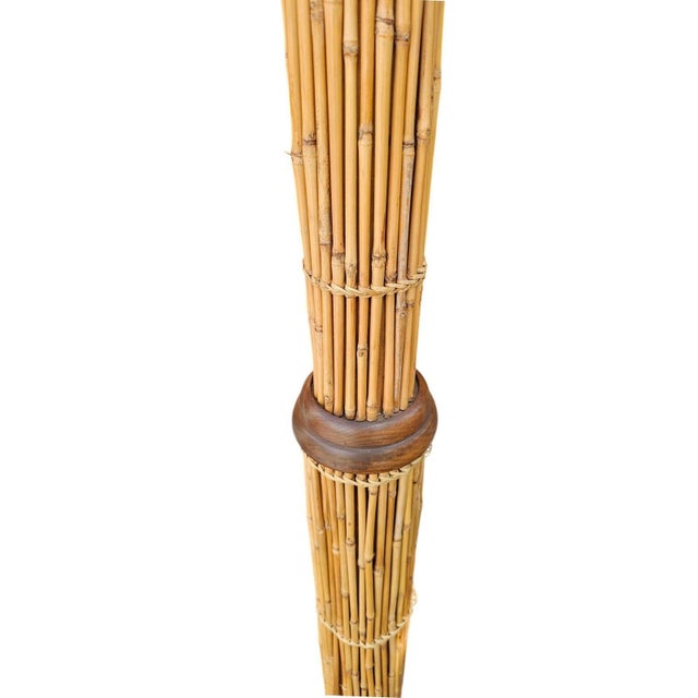 Handcrafted floor lamp features a striking column of bundled natural bamboo stalks secured with woven raffia-style ties....