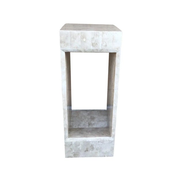 An unusual pedestal with an open center clad in tessellated fossil stone. There are chamfered edges of the open area with...