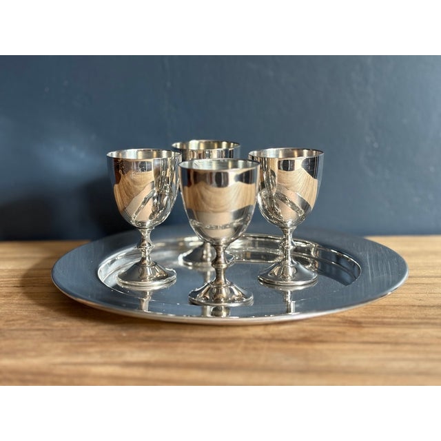 Set of four small stemmed cordial goblets in silverplate, with a plain round silverplate tray. Marked to the underside of...