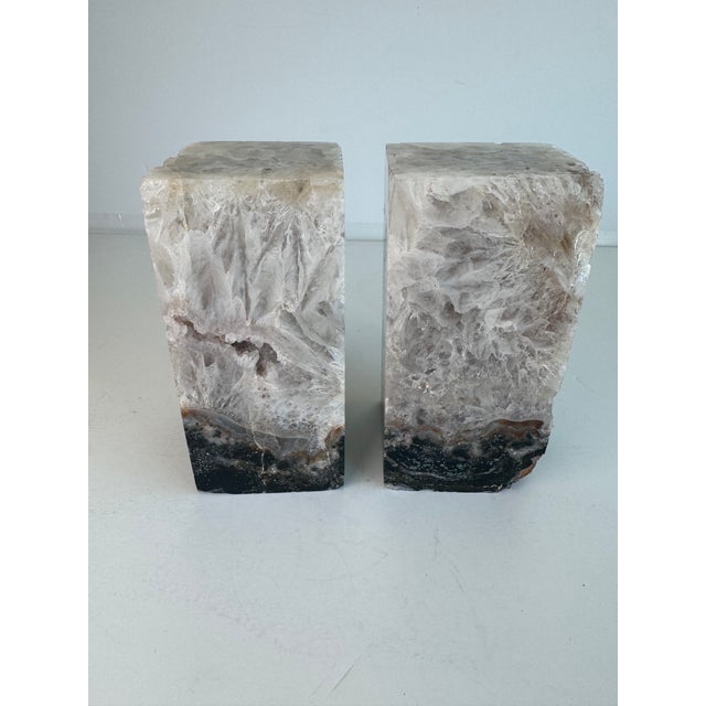 A pair of natural quartz stone bookends. They are greyish-purple-neutral in color with a dark black & brown bottom. Both...