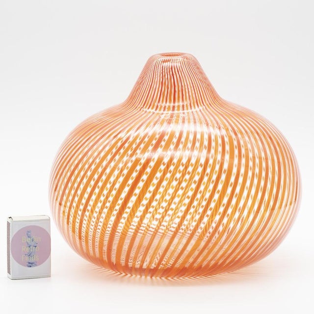 Hand-blown Filigrana vase with vivid orange and red threads suspended in clear glass. The rounded body and narrow neck...