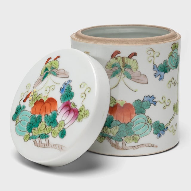 Used to store loose leaf tea, this small porcelain jar is decorated in a style of overglaze enameling known as "famille...
