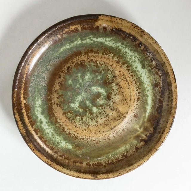 “Farsta” bowl or platter, made from stoneware in a smooth, thick form. Striking glaze in nuances of reddish brown, ochre...