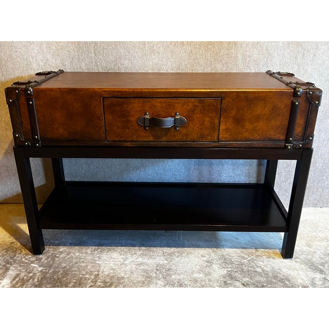 Vintage faux leather and wood suitcase or travel trunk console table featuring a center drawer, two hidden side drawers,...