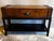 Vintage faux leather and wood suitcase or travel trunk console table featuring a center drawer, two hidden side drawers,...
