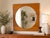 This vintage Mid-Century Modern wall mirror features a striking geometric composition with a large circular mirror...