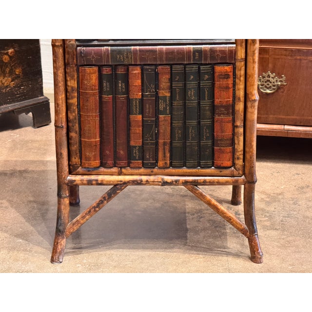 A small bamboo cabinet constructed with faux bamboo-turned uprights and legs, fitted with a single book-front door...