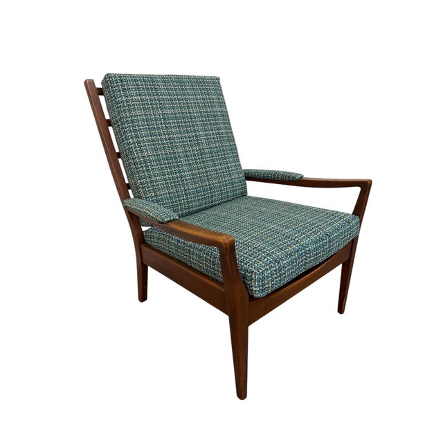 This striking Mid-Century Danish Modern arm chair showcases the clean lines, warm materials, and timeless craftsmanship...