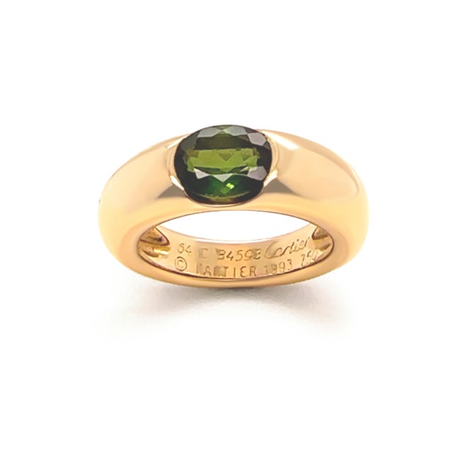 A rare vintage Cartier Ellipse ring crafted in 18ct yellow gold, featuring an oval olive-green peridot in a classic,...