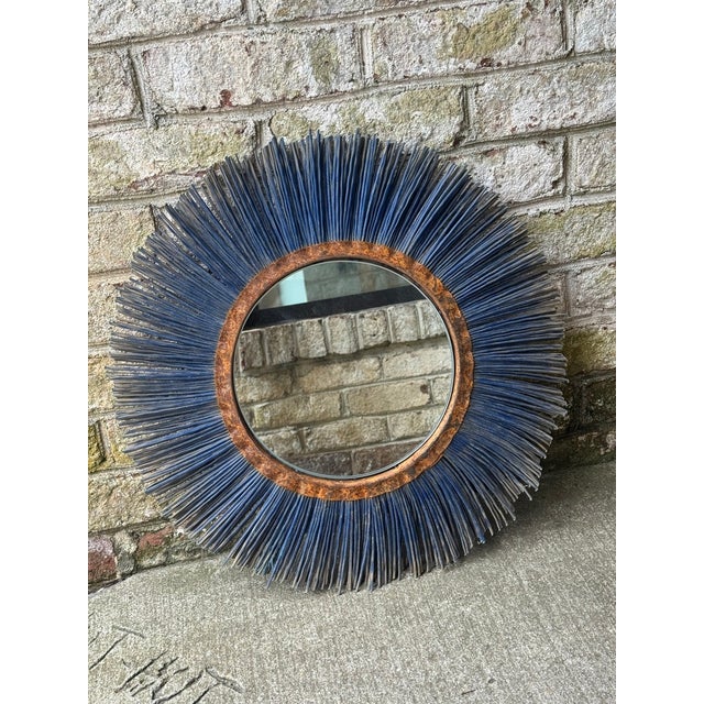 Vintage salvage wall mirror. This round wall mirror features a rusty metal boarder followed by a layer of blue fringe,...
