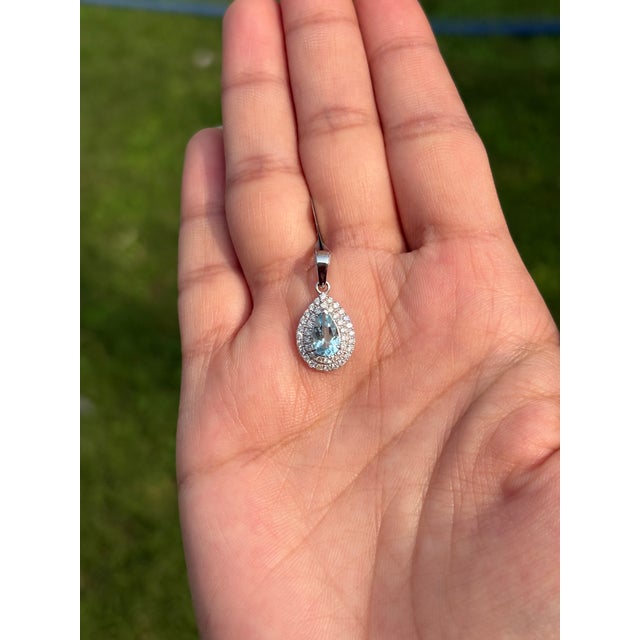 This pear-cut aquamarine and diamond double halo drop pendant in 14K white gold. The pendant features a pear-cut...
