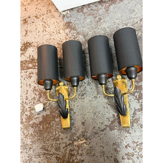 Design Plus Gallery presents a Pair of Neoclassical Wall Sconces. Each sconce showcases a vertical brass backplate with a...