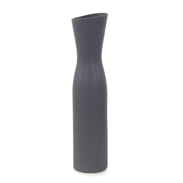 Each vase boasts a modern asymmetrical form, lending an intriguing sense of dynamism to its appearance. The charcoal gray...