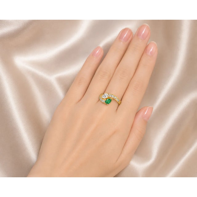 Material: 18K Yellow Gold - elegant and durable Main Stone: Tear-Shaped Emerald - vibrant and eye-catching Accent Stones:...