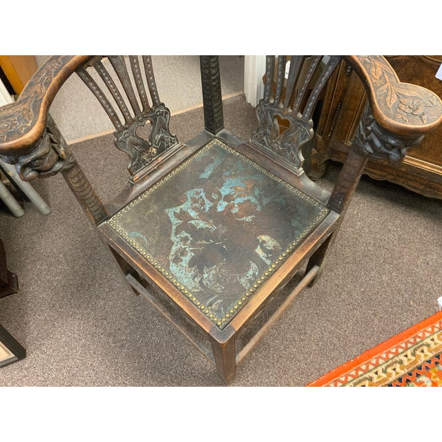 Late 19th century heavily carved oak corner chair. With leather seat and nailhead detail.Victorian Gothic carved grotesque...