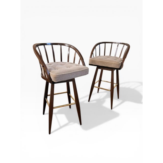 A striking pair of swivel bar stools by Edward Wormley for Dunbar Furniture, masterfully restored to highlight their...