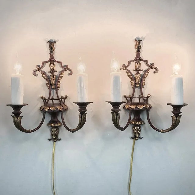 Pair of Antique Italian Wrought Iron and Painted Wood Sconces features a subdued burgundy color accented with gold on the...