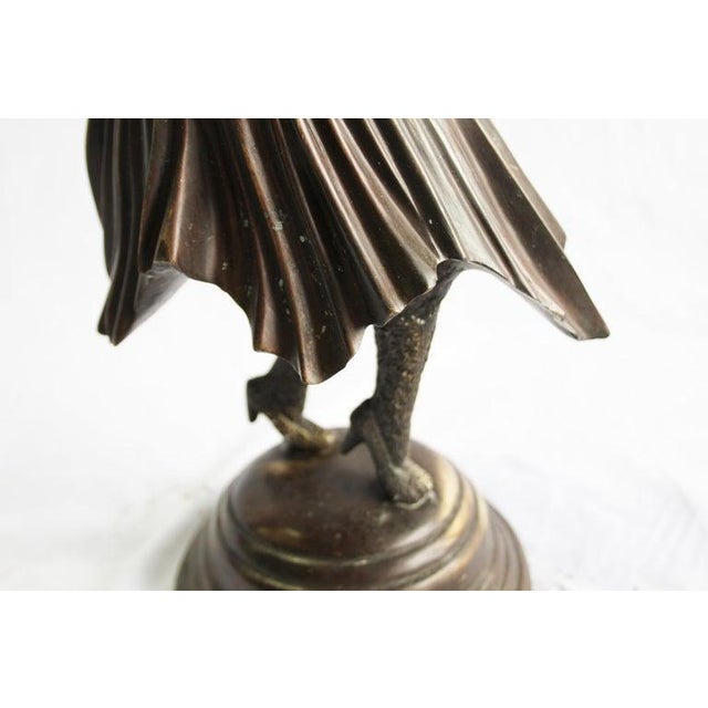 After Demetre Chiparus. An Art Deco style bronze figure. Mid-20th century. Of dark brown patination. On circular stepped...