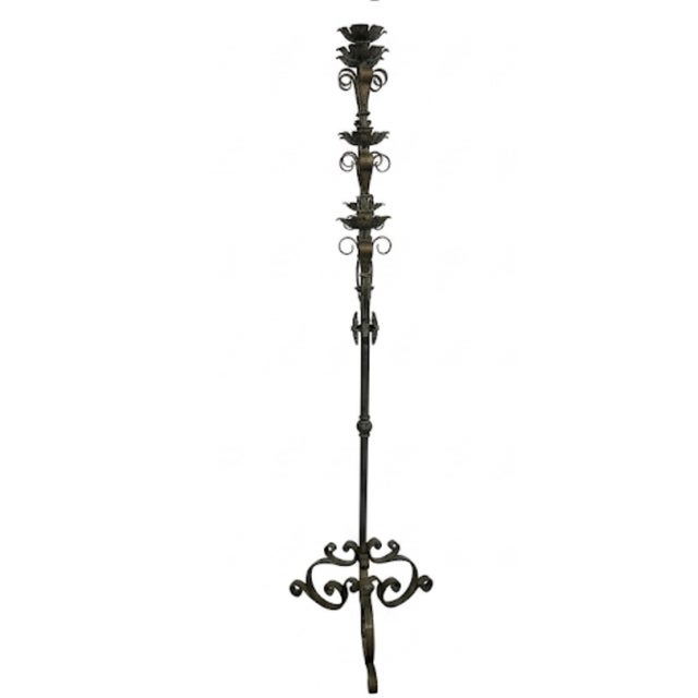 An impressive statement piece of architectural decor, this substantial floor-standing wrought iron candelabra features a...