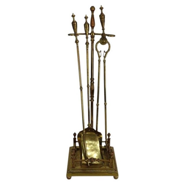 This antique Neoclassical fireplace tool set, dating to approximately 1920, is crafted entirely from brass. The set...