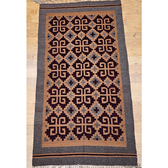Celebrate the beauty of traditional craftsmanship with this vintage Native American Navajo area rug, featuring a warm and...