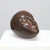 This intimate bronze sculpture depicts a reclining head in a state of calm introspection. Its smooth, rounded contours and...