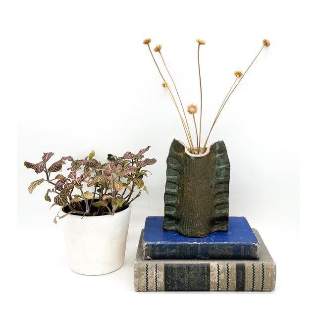 Entrancing sculptural vessel, hand made from ceramic. Features a unique pattern of ruffles down the sides and a gorgeous,...