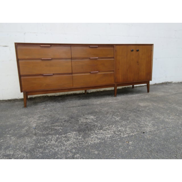 This high quality Dresser is made of wood, walnut, laminated, and veneer. The Dresser was made by American of Martinsville...