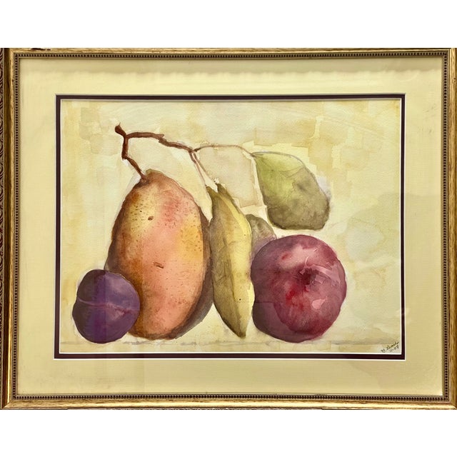 A delicately rendered watercolor still life of fruit. Enclosed in an ornate gilt wood frame with pale yellow matting....